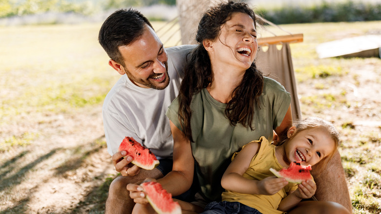 Family enjoying watermelon on hammock