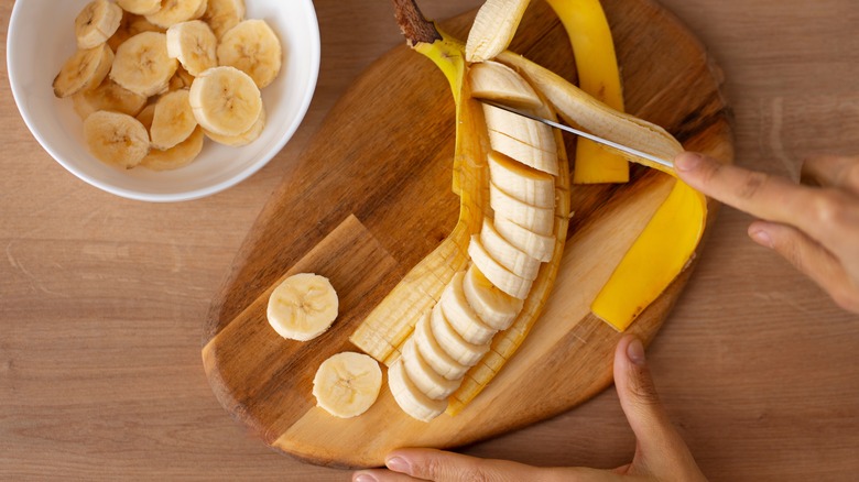 Hands slicing banana