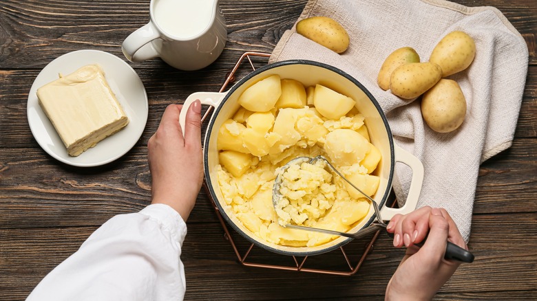 Hand mashing potatoes with butter and cream