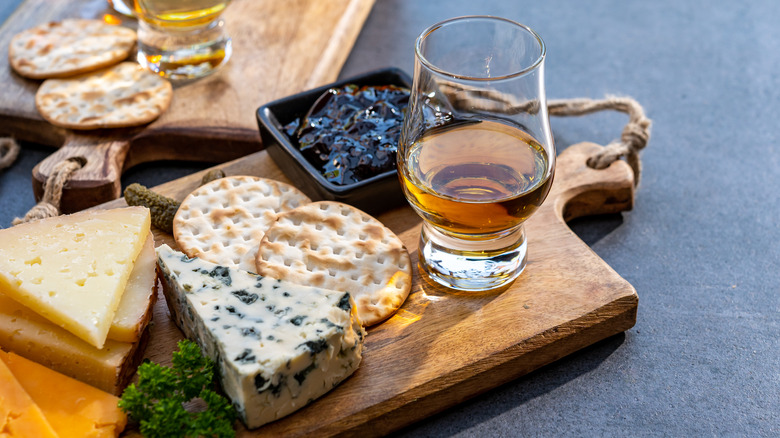 glass of whisky on cheese board