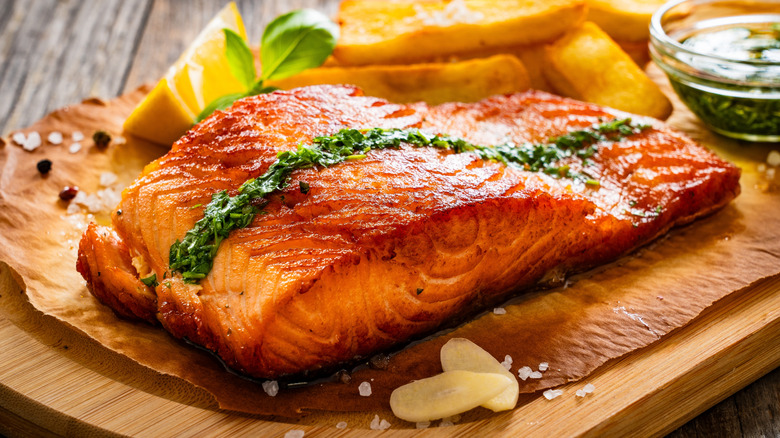 Seared salmon fillet with cilantro aioli, lemons, and fries