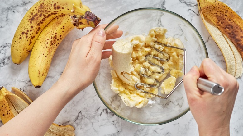 cook mashing bananas in bowl