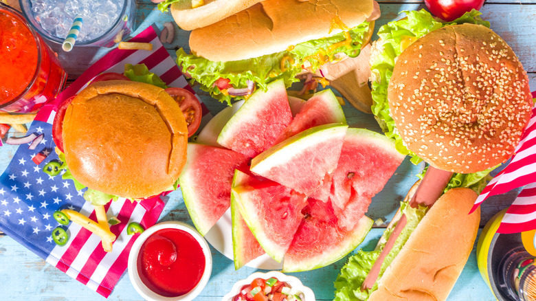 Burgers, hot dogs, and watermelon slices on a table