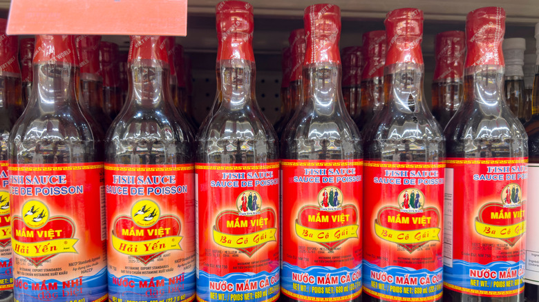 Bottles of fish sauce on a grocery store shelf.