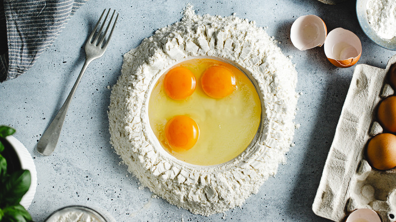 eggs in the middle of pile of flour