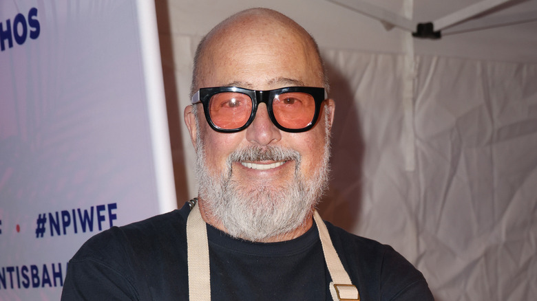 Andrew Zimmern wearing glasses and apron