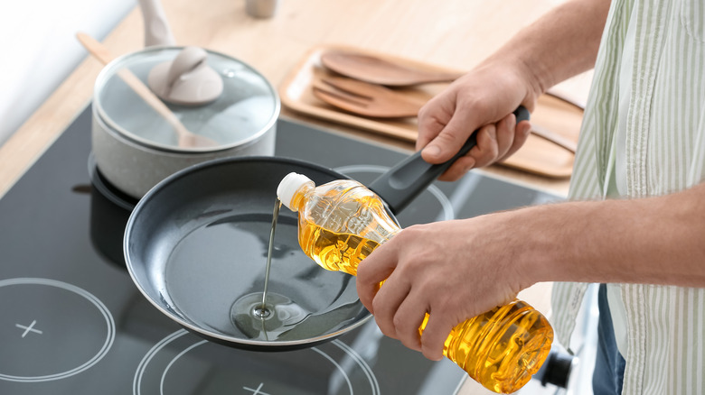 Pouring cooking oil in pan 