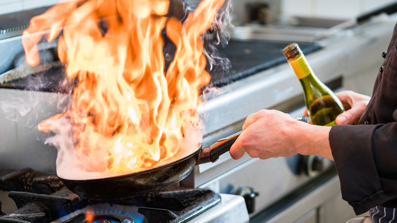 flambéing food in flaming pan