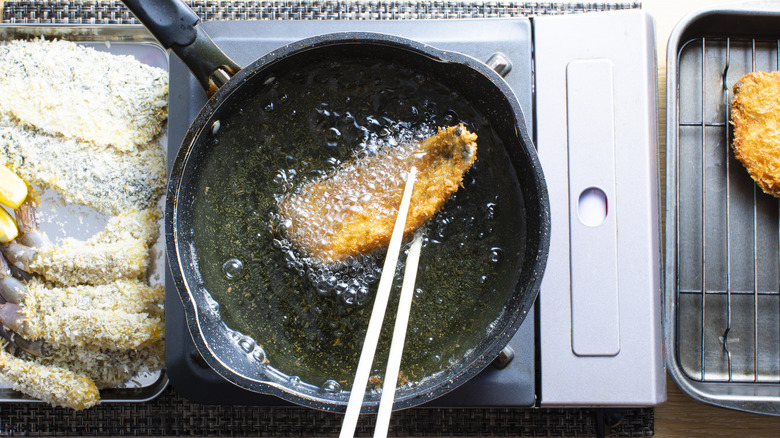 frying piece of breaded fish in oil