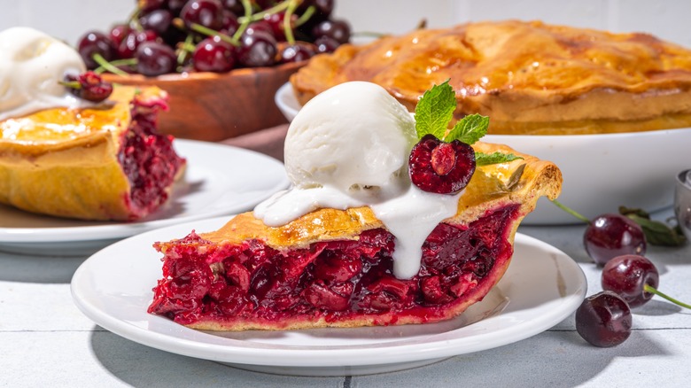 A slice of cherry pie with ice cream