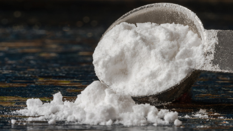 Cream of tartar spilling onto table from tablespoon