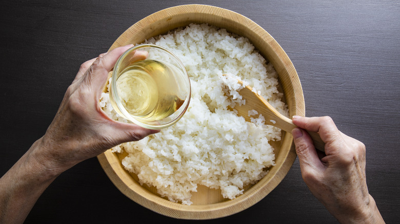 Seasoning a bowl of sushi rice.