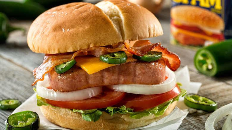 Grilled Spam on hamburger bun with jalapenos, bacon, onions, tomatoes