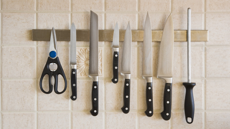 knives and other cutting utensils displayed on a wall rack