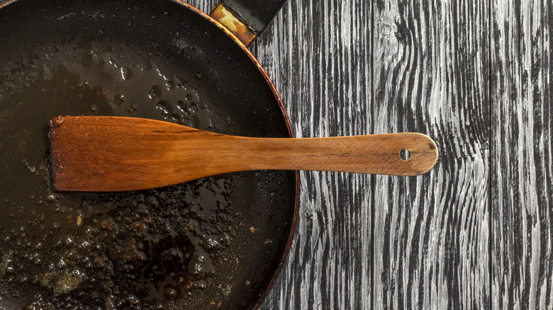 A dirty pan with a wooden spatula