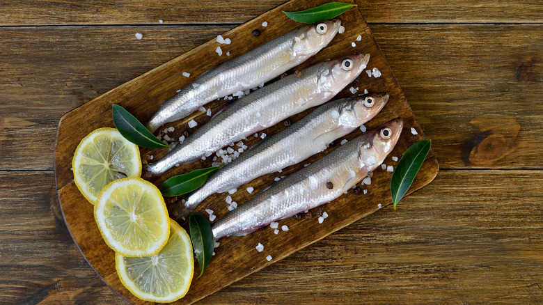 whole raw smelt on a cutting board