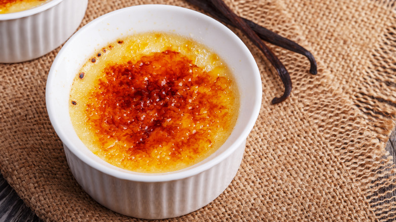 creme brulee on a table next to vanilla beans