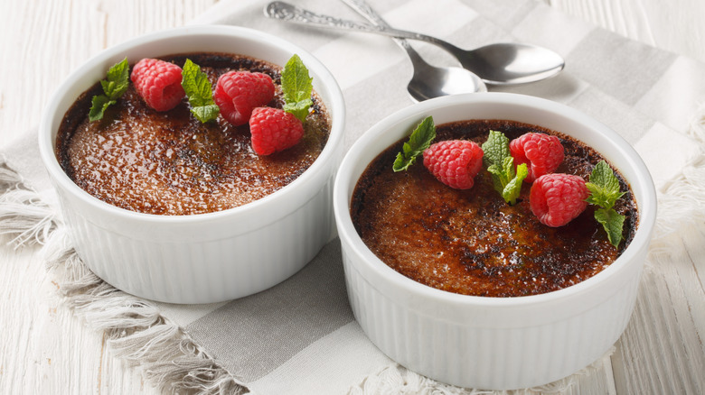 two creme brulees with raspberry and mint garnish