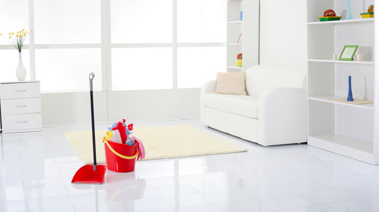 White floor with mop and bucket of cleaning tools