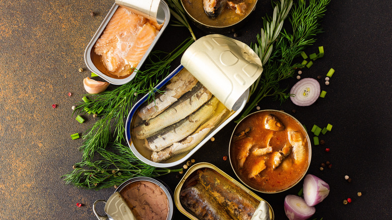 Tinned seafood surrounded by herbs