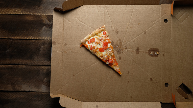 A slice of pizza on an empty box