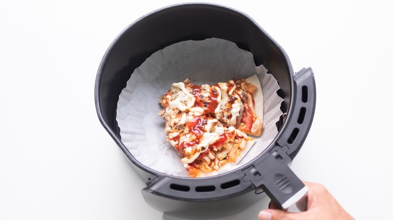 Pizza slice in an air fryer basket