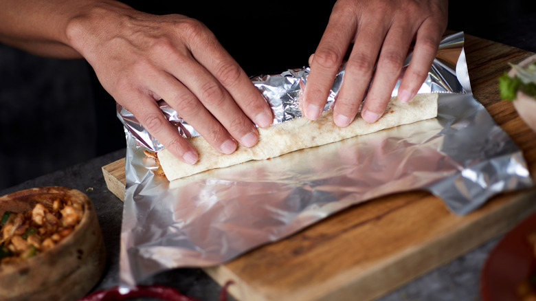 hands wrapping a homemade burrito