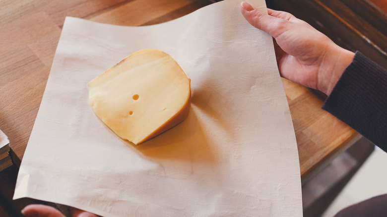 person wrapping cheese in paper