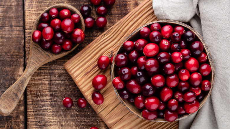 Fresh cranberries in wooden bowl with spoon