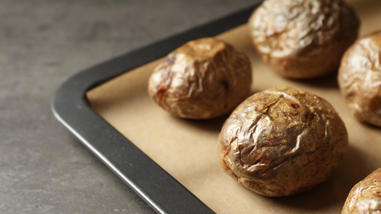 Baked potatoes on a lined baking tray