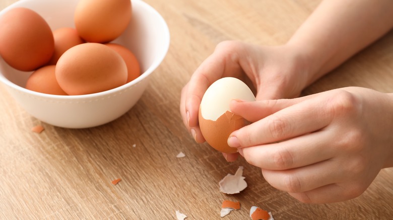 person peeling hard-boiled eggs