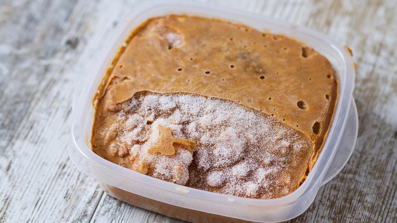 A container of frozen food with freezer burn