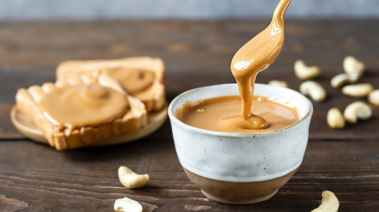 A bowl of peanut butter with a spoon