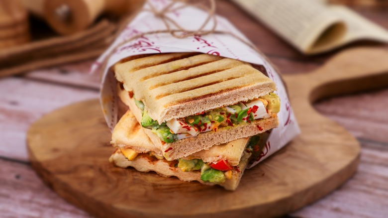 Grilled tofu sandwich with egg and vegetables wrapped in paper