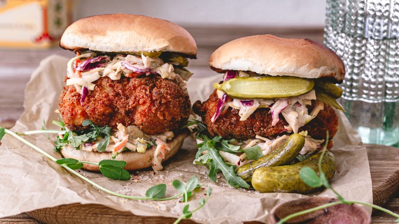 Two Nashville hot chicken sandwiches with pickles and colelslaw