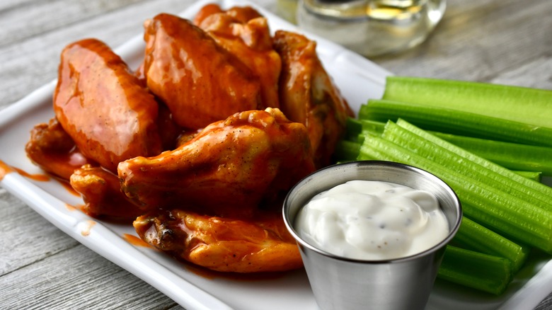 Buffalo chicken wings in sauce with ranch dressing and celery