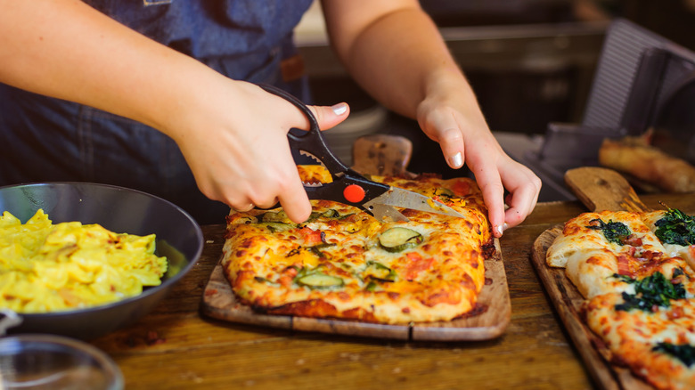 Cutting pizza with scissors