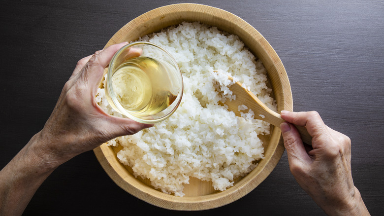 Seasoning sushi rice in a wooden bowl