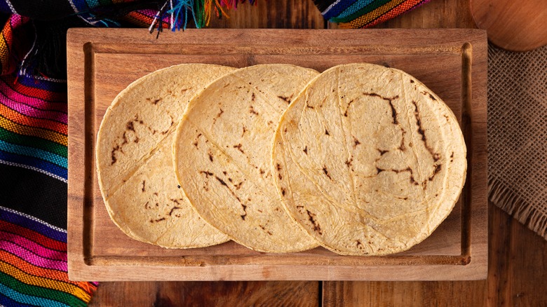 homemade corn tortillas over wooden board