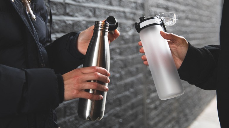 People holding reusable water bottles