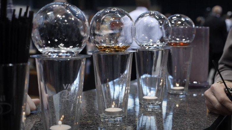 Four Vaportini devices lined up on a counter with different spirits.