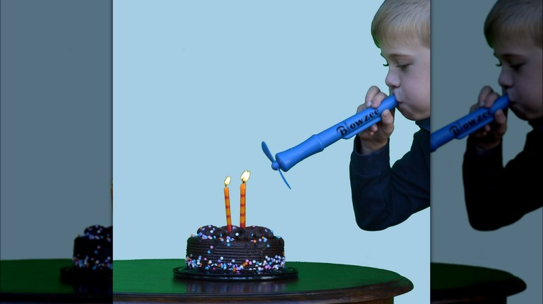 Kid blowing birthday candles with the Blowzee