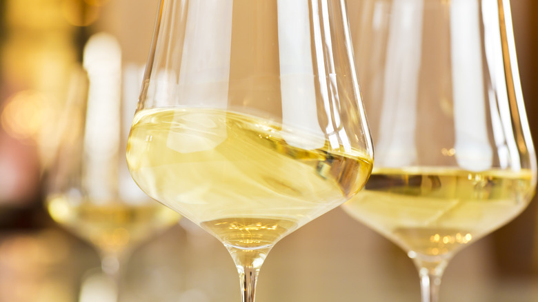 Glass of white wine with pans in background