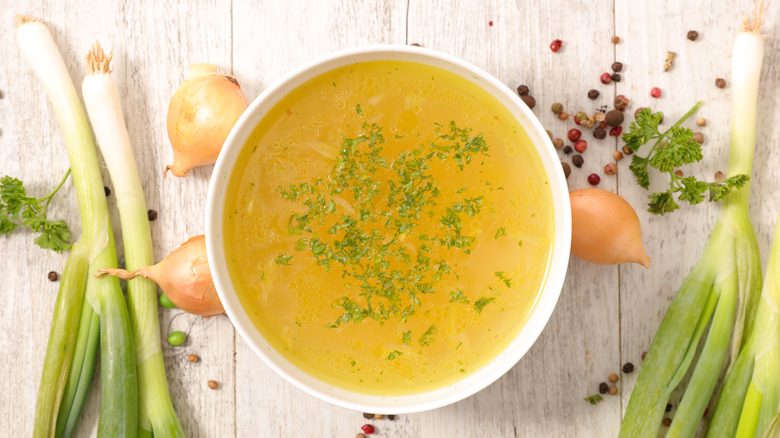 bowl of chicken broth with herbs