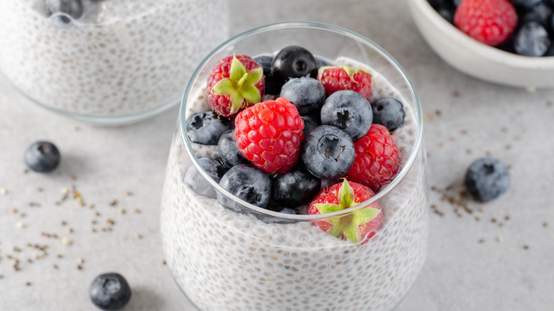 Glass of chia pudding topped with assorted berries