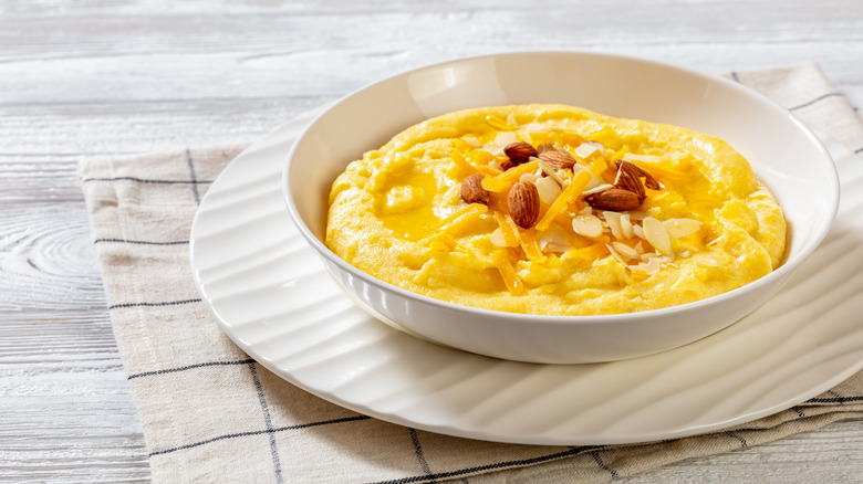 Bowl of vegan corn grits with vegan cheese and almonds