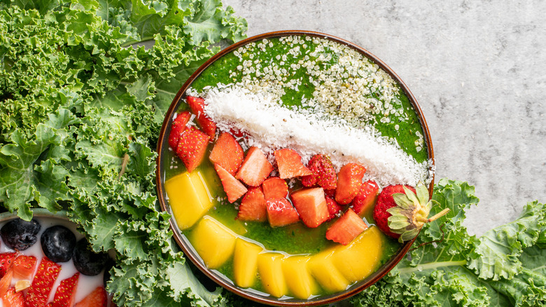 Vegan smoothie bowl with kale, berries, seeds, and coconut