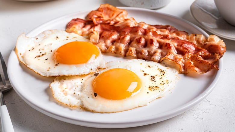 Plate of two eggs over easy and bacon