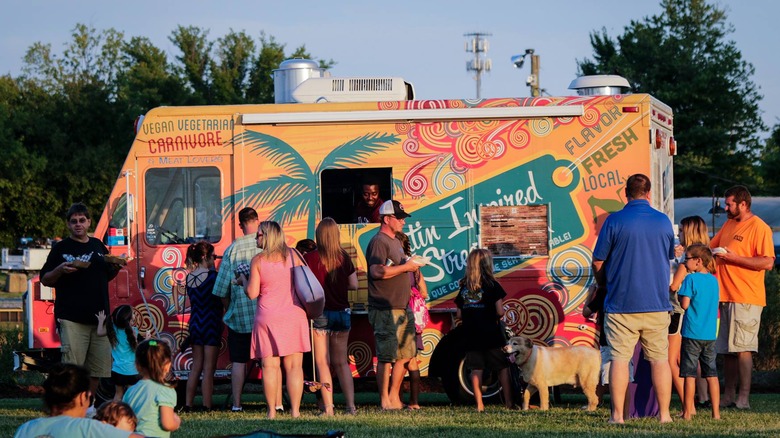 People standing outside a food truck