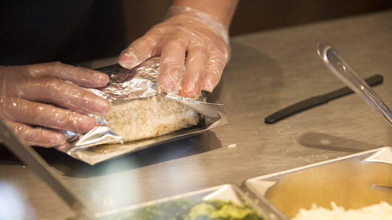 Employee rolling a Chipotle burrito